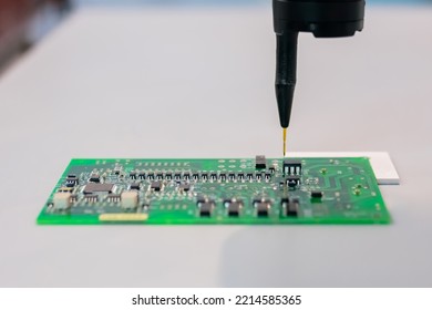 Automatic Manipulator With Dispenser Needle Working With SMT Computer Circuit Board - Close Up. Automated Technology, Industrial, Robotic, Electronic, Manufacturing Concept