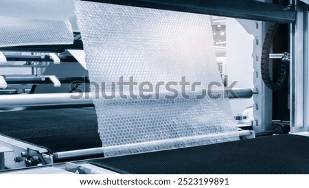 Automatic polyethylene air-bubble packaging roll tape film machine with lighting effect in blue background in full screen