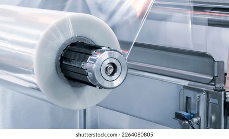 Automatic polyethylene plastic bag production machine with lighting effect. Close-up of the roller of the plastic bag production machine in the light blue scene. product packaging concept - Shutterstock ID 2264080805