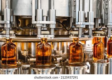 Automatic production line fills glass bottles with cognac - Powered by Shutterstock