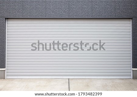 Automatic silver metal roller shutter doors on the ground floor of the house