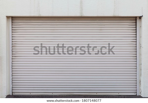 Automatic silver roller shutter doors on the ground\
floor of the house