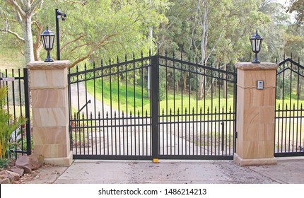 Automatic Swing Open Metal Front Gates With Stone Pillars And Lights Either Side