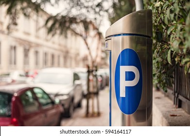 Automatic ticket machine parking on a city street with blurred cars. Blue sign of parking cars.