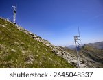 Automatic weather stations gathering meteorological data on a mountain ridge, contributing to climate change research.