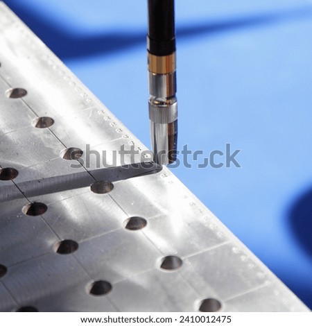 Automatic welding torch on welding table closeup