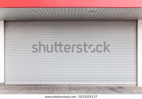 Automatic white roller shutter doors on the ground\
floor of the house