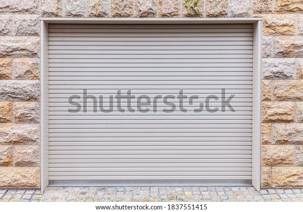 Automatic white roller shutter doors on the ground\
floor of the house