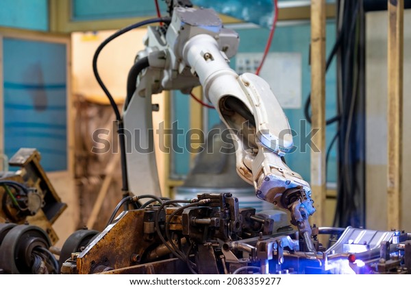 Automation concept: Selective\
focus on welding head of robot in automotive part manufacturing\
plant.