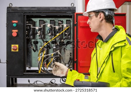 Automation Engineer Inspecting Control Panel in Industrial Factory Male Engineer Checking Electrical Wiring and Robot Control System Engineer with Hard Hat and Gloves Working on Control Panel
