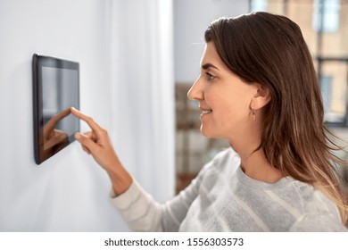 automation, internet of things and technology concept - woman using tablet pc computer at smart home - Shutterstock ID 1556303573