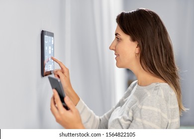 automation, internet of things and technology concept - woman using tablet pc computer and smartphone at smart home - Shutterstock ID 1564822105