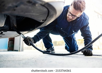 An Auto-mechanic Checking On Car Exhaust Gases On A Technical Service.