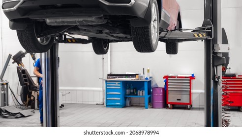 Automobil On Lift For Wheel Suspension Maintenance. Car Service Garage.