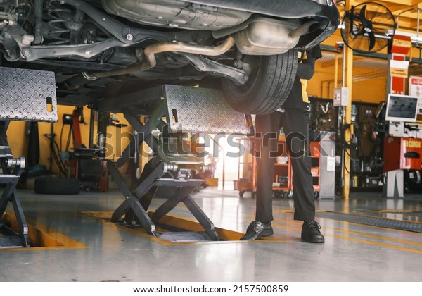 Automobile car repair workshop garage concept,\
mechanic engineer fixing broken vehicle wheel tyres, professional\
male mechanic worker serviceman technician repair maintenance\
motors and machine.