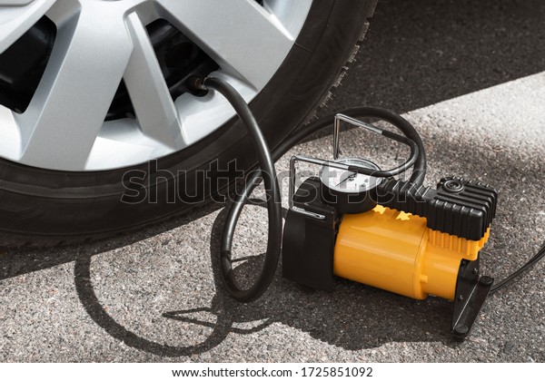 \
Automobile compressor. Electric pump inflates\
a car wheel\
close-up