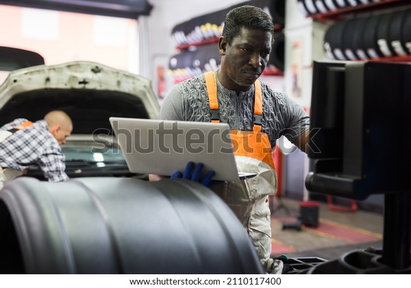 Automobile computer diagnosis. Car mechanic\
repairer looks for engine\
failure