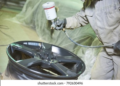 Automobile disc restoring. Painter painting light alloy wheel with spray - Shutterstock ID 792630496