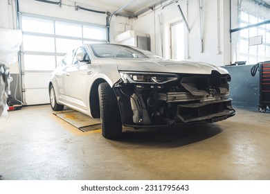 Automobile with front end damage inside a car body repair shop. High quality photo