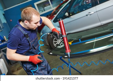 Automobile Glazier Adding Glue On Windscreen Or Windshield Of A Car In Auto Service Station Garage Before Installation