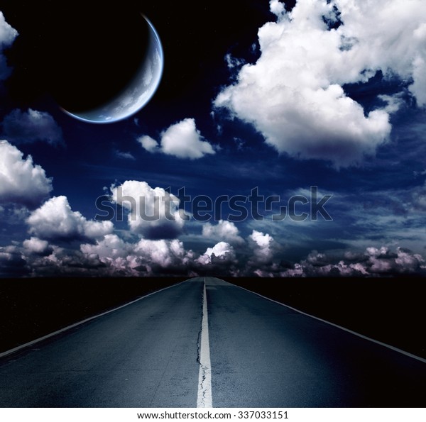 Automobile headlights\
illuminated the road in the field. Night landscape with road,\
clouds and the moon