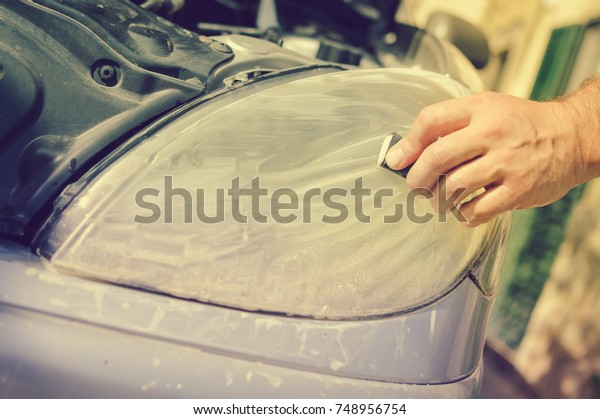 Automobile industry.\
Close up on car detail - male hand polish in auto repair shop\
background. Professional person during mechanical maintenance,\
industrial part transport\
renovation