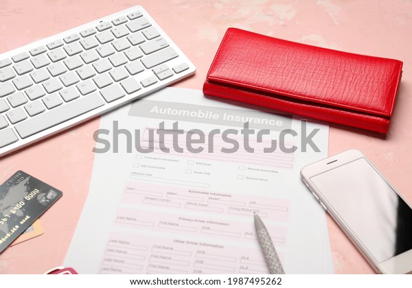 Automobile insurance form with mobile phone\
and computer keyboard on color\
background