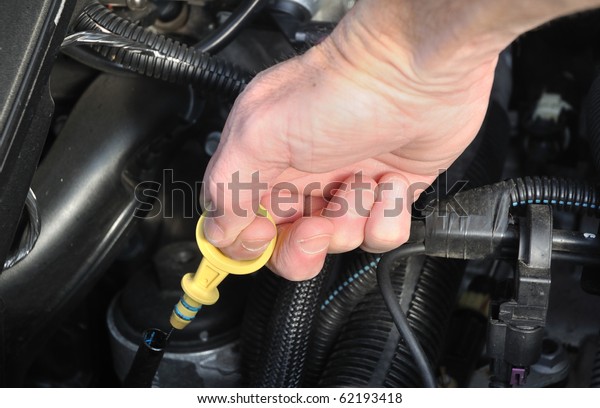 Automobile Maintenance - Pulling the Engine\
Dipstick to Check the Oil\
Level