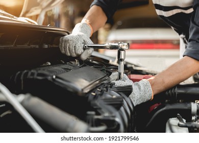 Automobile mechanic repairman hands repairing a car engine automotive workshop with a wrench, car service and maintenance,Repair service. - Powered by Shutterstock