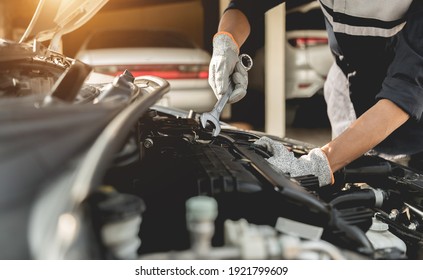 Automobile mechanic repairman hands repairing a car engine automotive workshop with a wrench, car service and maintenance,Repair service. - Shutterstock ID 1921799609