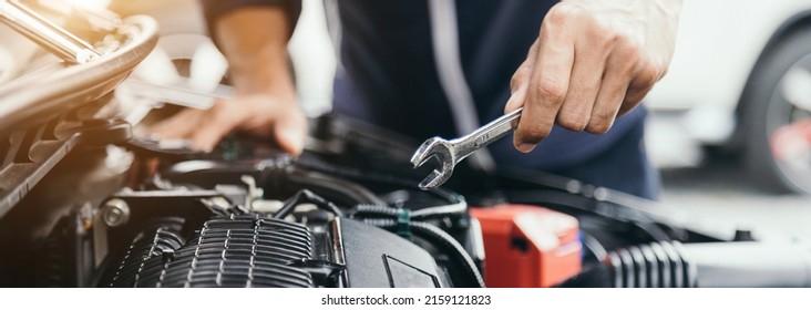 Automobile mechanic repairman hands repairing a car engine automotive workshop with a wrench, car service and maintenance,Repair service. - Powered by Shutterstock