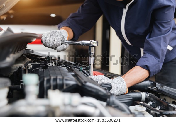 Automobile mechanic repairman hands repairing a\
car engine automotive workshop with a wrench, car service and\
maintenance,Repair\
service.