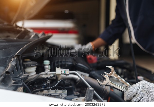 Automobile mechanic repairman hands repairing a
car engine automotive workshop with a wrench, car service and
maintenance,Repair
service.