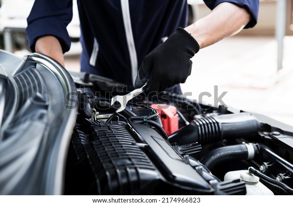Automobile mechanic repairman hands repairing a\
car engine automotive workshop with a wrench, car service and\
maintenance , Repair\
service