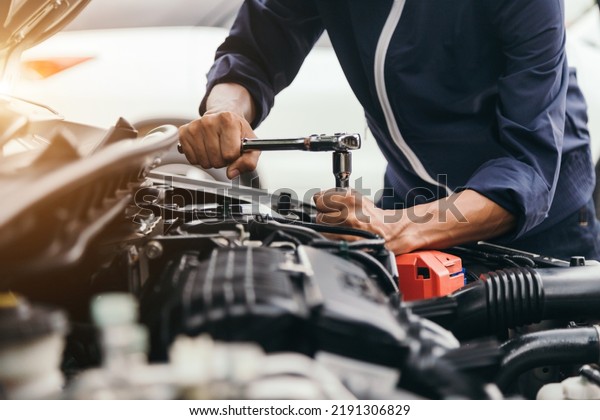 Automobile mechanic repairman hands repairing a\
car engine automotive workshop with a wrench, car service and\
maintenance , Repair\
service.