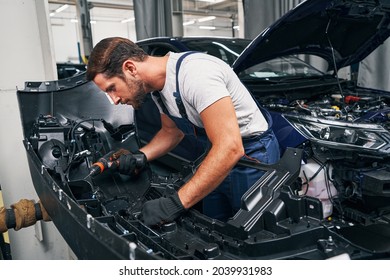 Automobile Mechanic Using Drill On Car Part