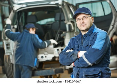 Automobile Repairman Worker Portrait In Automotive Industry In Front Of Car Under Repair