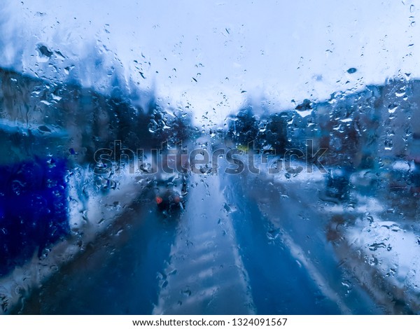 The Automobile road glass and water drops close up.\
Rain on the road.