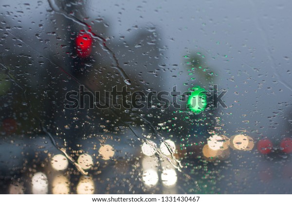 Automobile road glass and water drops close up. Rain\
in the city road