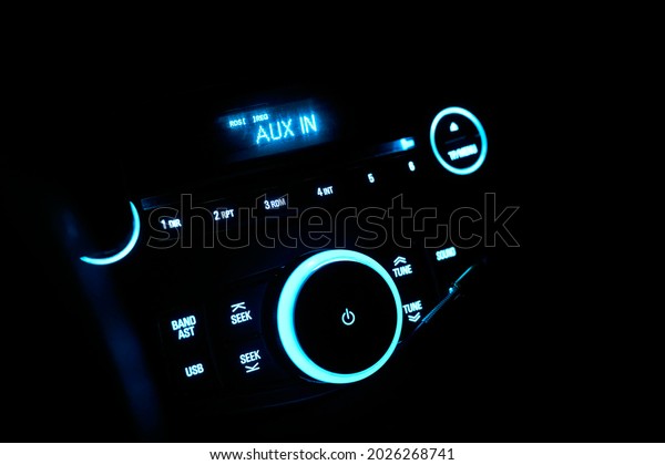 Automobile stereo in neon\
light at night. Dashboard with audio equipment in cabin of the\
modern new car