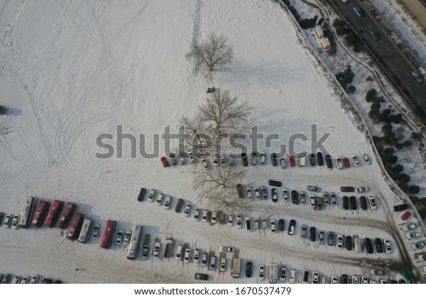 Automobiles lining up in the\
snow