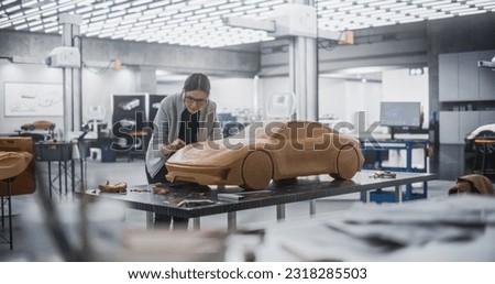 Automotive Artist Making Final Strokes on Her Latest Concept Car Creation. Enthusiastic Female Designer Working on a New Prototype, Sculpting Industrial Plasticine Clay 3D Model of a Sporty Coupe.