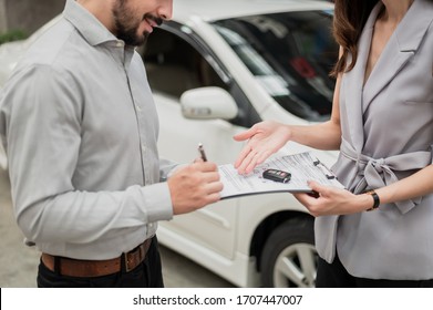 Automotive Business, Car Sale Or Rental Concept : Happy Customer With Car Dealer Agent Making Deal And Signing On Agreement Document Contract In Auto Showroom Or Car Dealer Office.