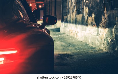 Automotive Concept. Modern Luxury Car In The Dark City Alley During Late Night Hours. Vehicle Rear Lights.