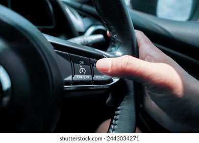 Automotive cruise control system on the steering wheel in a car , driver pressing cruise control button , Automotive technology concept - Powered by Shutterstock