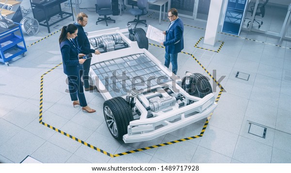 Automotive Design Engineers Talking While Working Stock Photo (Edit Now