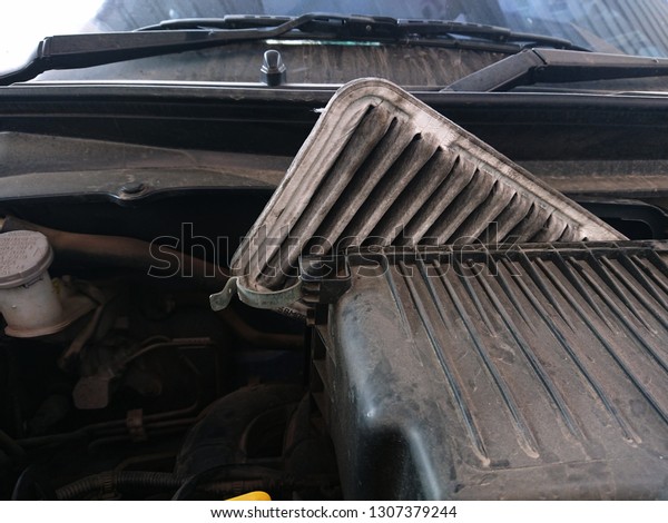 Automotive dirty engine air filter in the\
engine air flow with more dust in engine\
room