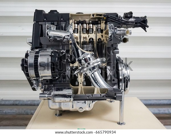 an automotive engine with parts cut away to\
reveal the internal workings