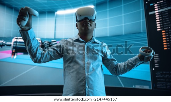 Automotive Engineer Making Presentation of a\
Modern VR Software Testing and Developing Vehicle Platforms.\
Engineer Uses Headset and Controllers to Showcase Functionality on\
a Big Screen on\
Stage.