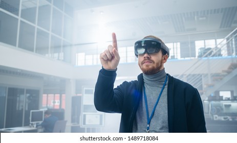 Automotive Engineer Using Augmented Reality Headset and Making Touching Gestures of Virtual Objects in the Air. In Innovation High Tech Laboratory Facility with Futuristic Atmosphere.